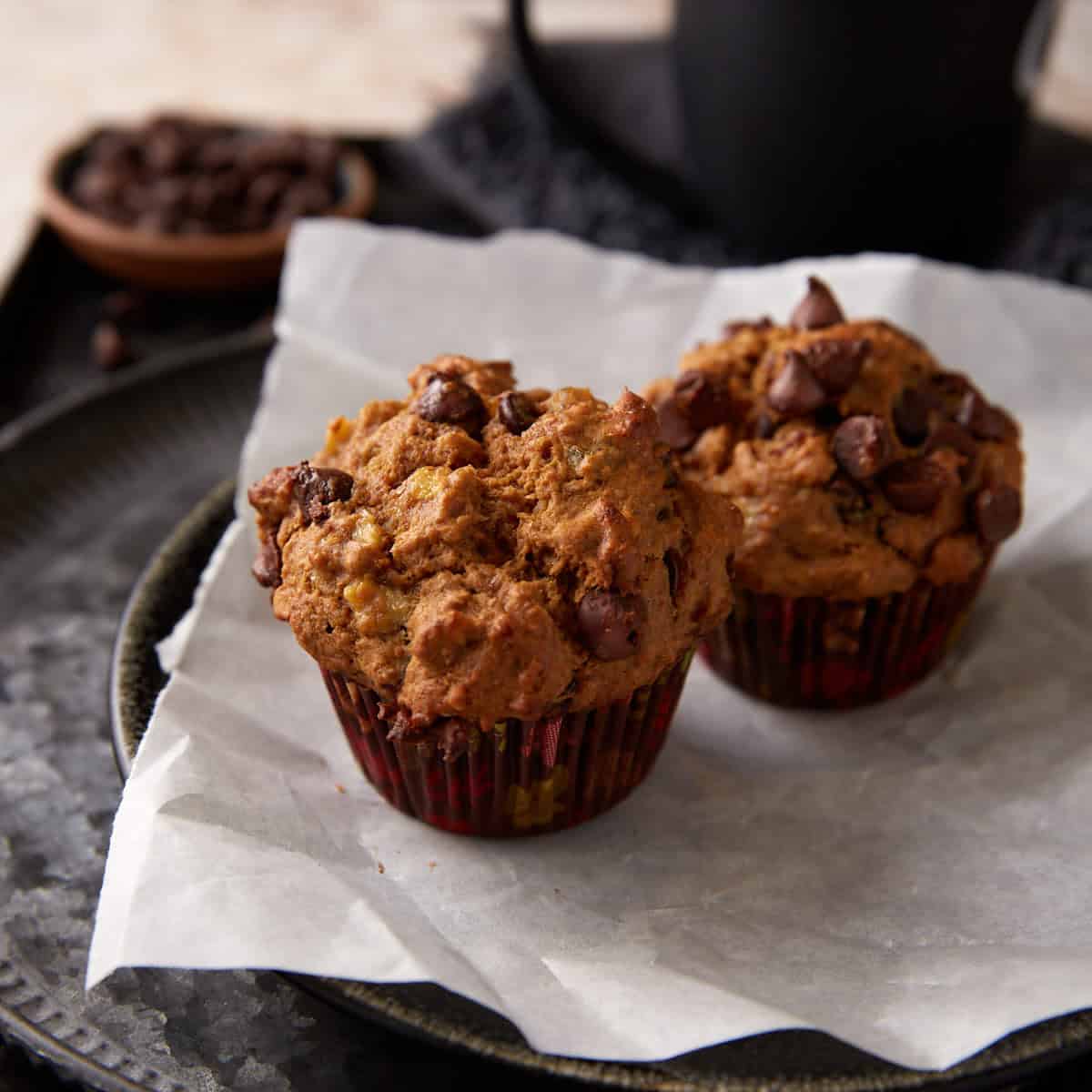 Banana muffins with chocolate chips on a plate.