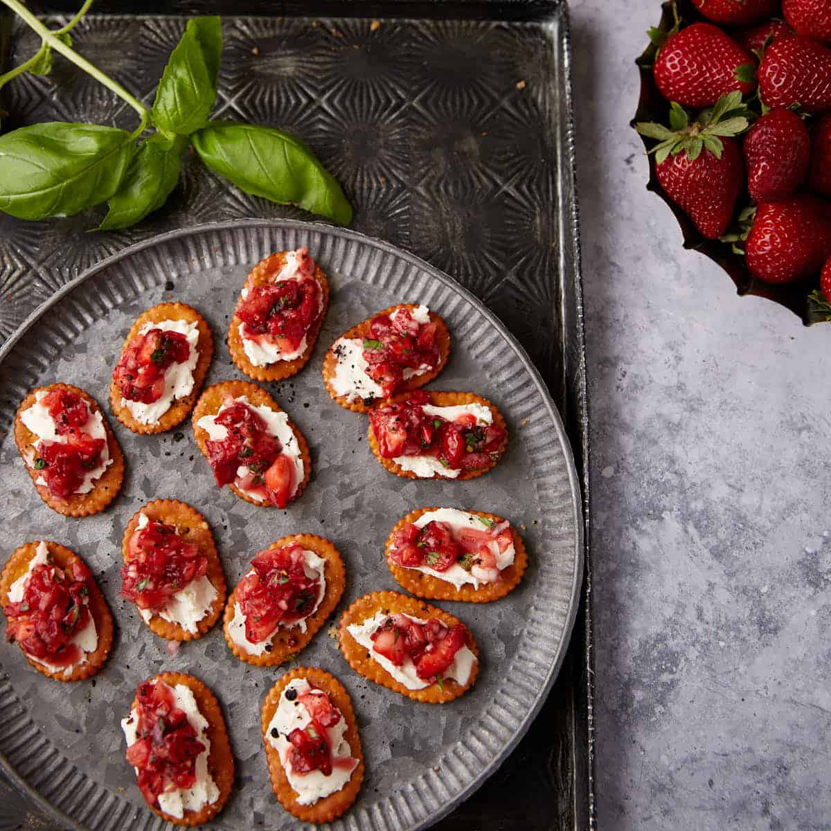 Pretzel crackers topped with cream cheese and strawberries.