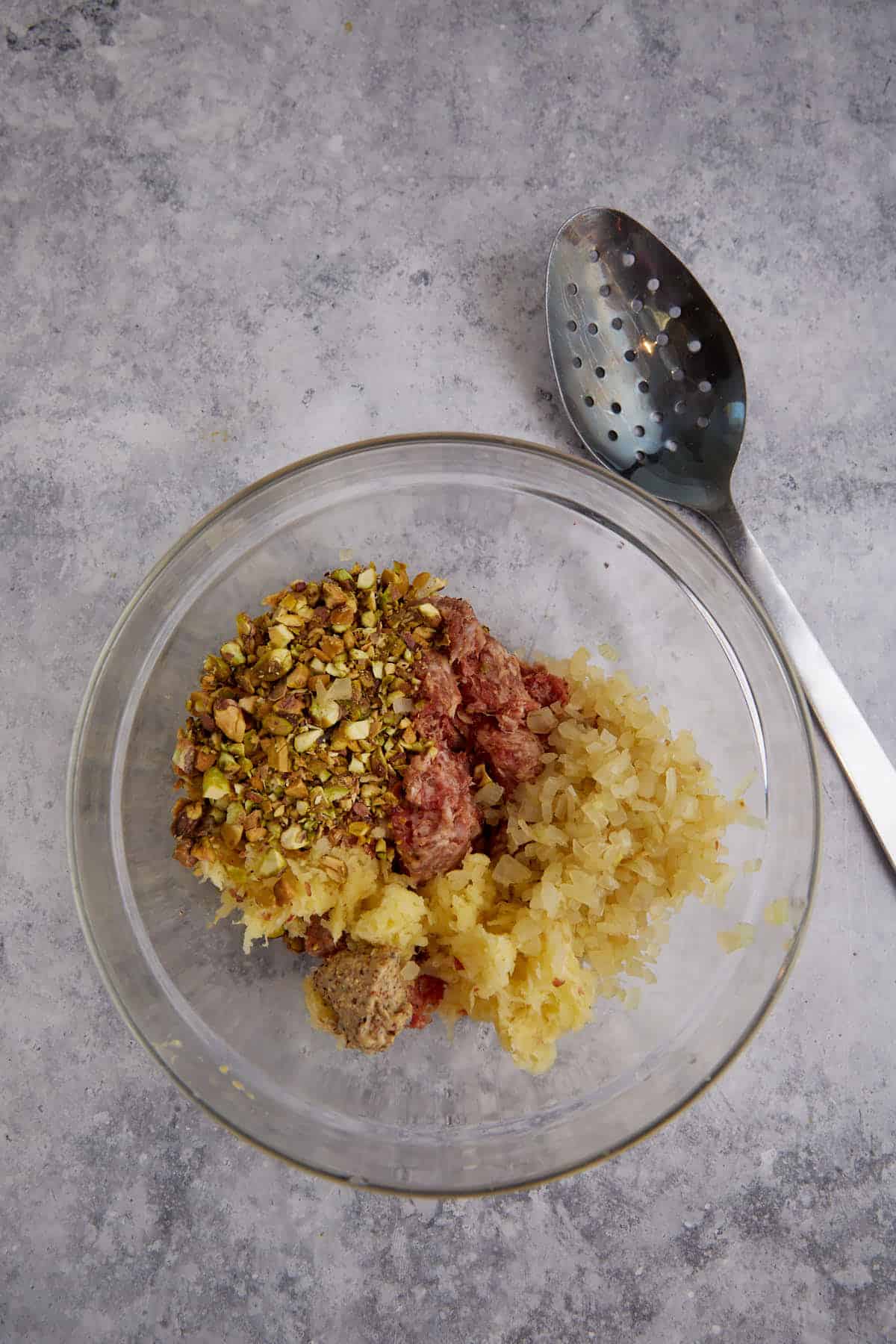 Apples, sausage and onions in a bowl.