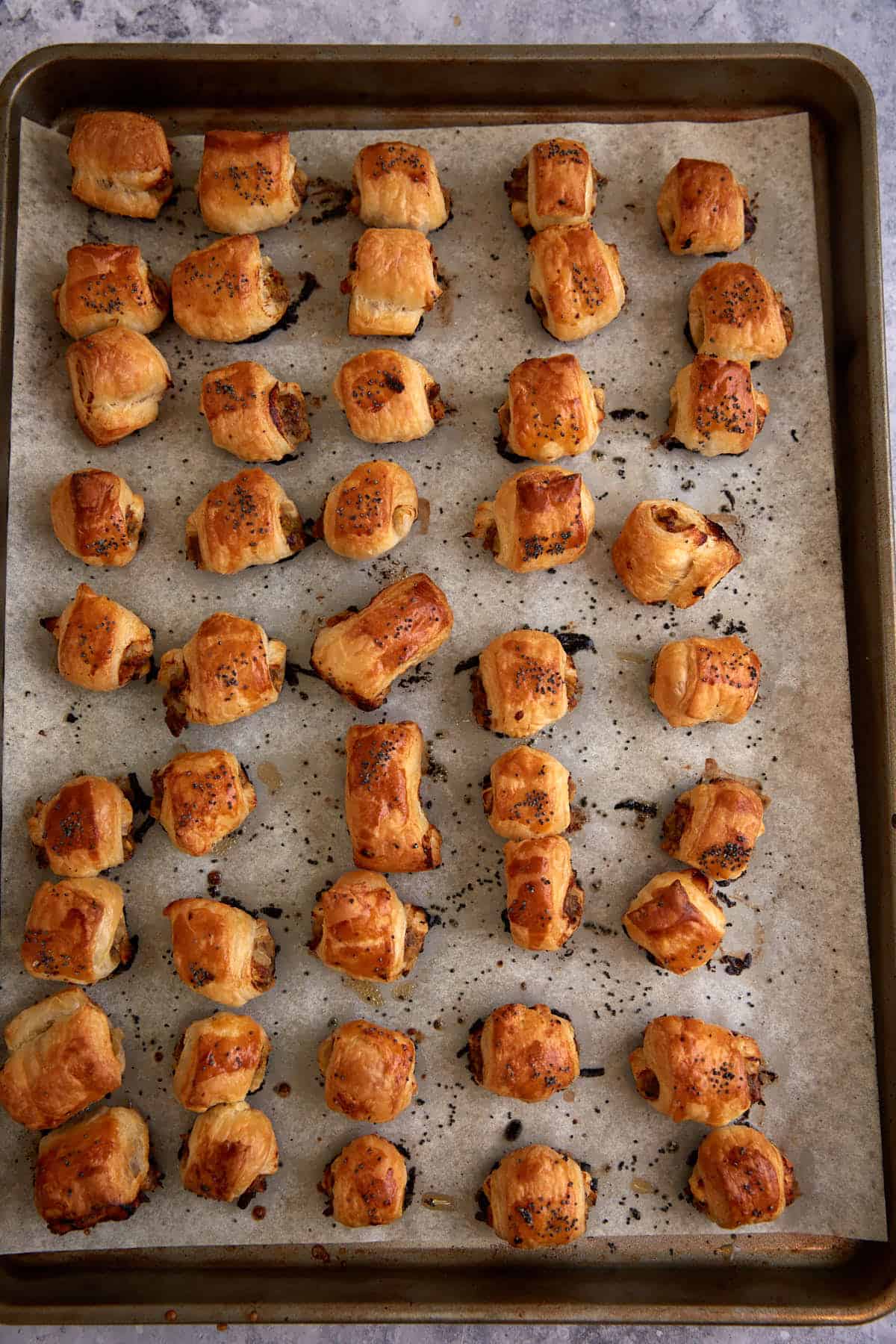 A baking sheet with baked puff pastry rolls.