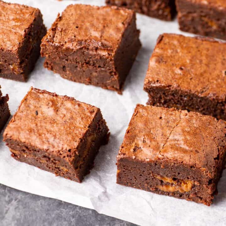 Dulce de leche brownies cut on parchment paper