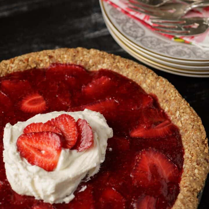 A strawberry pie topped with whipped cream
