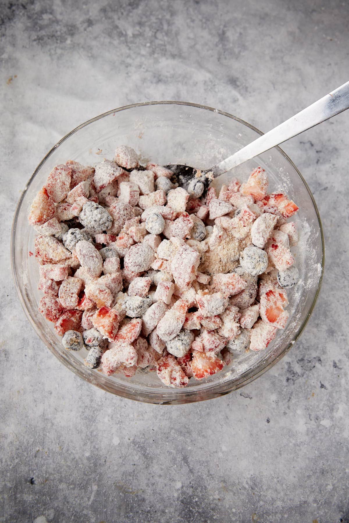 Berries coated in flour and sugar in a bowl.