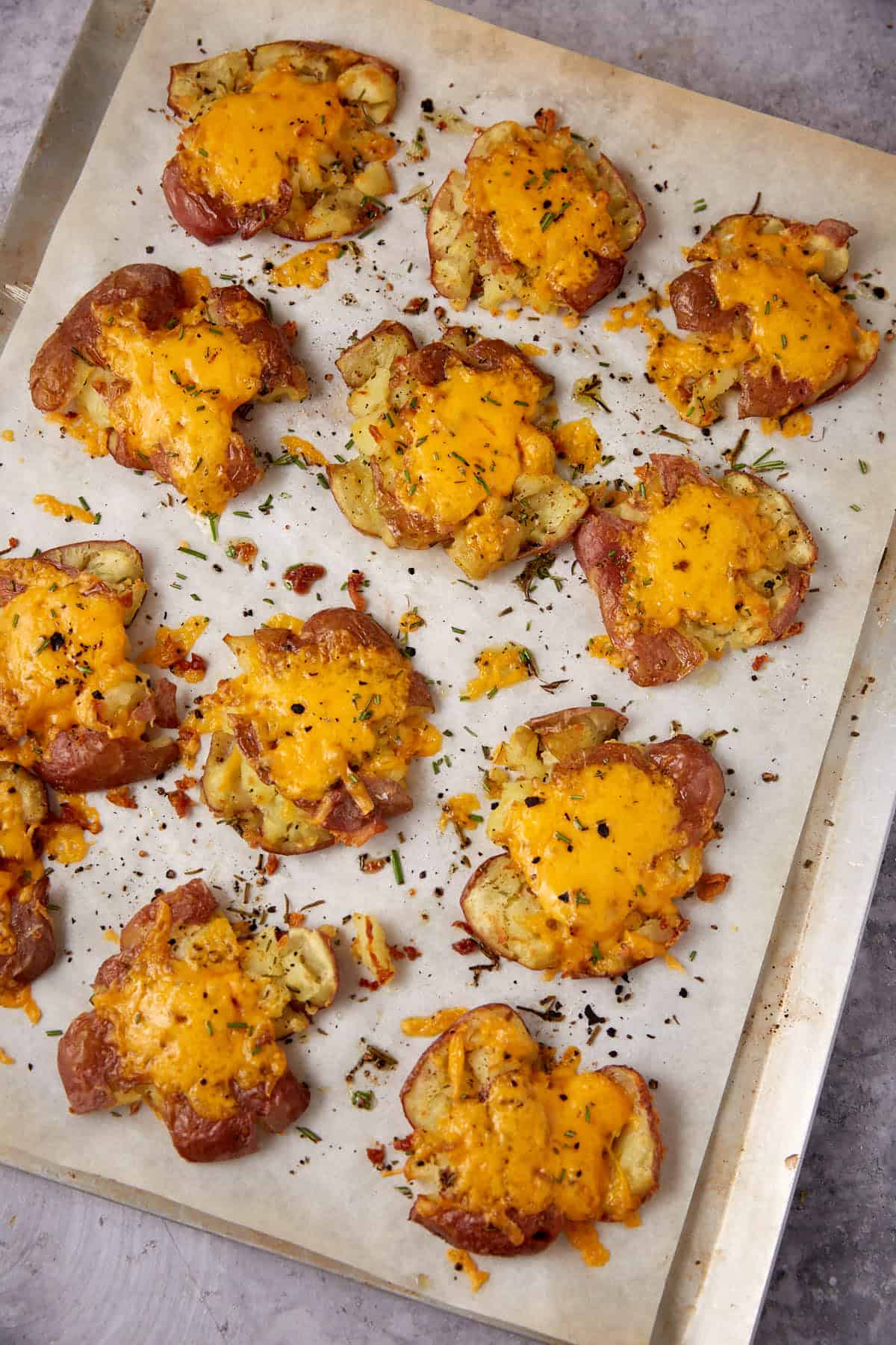 Crushed and roasted new potatoes on a baking sheet.