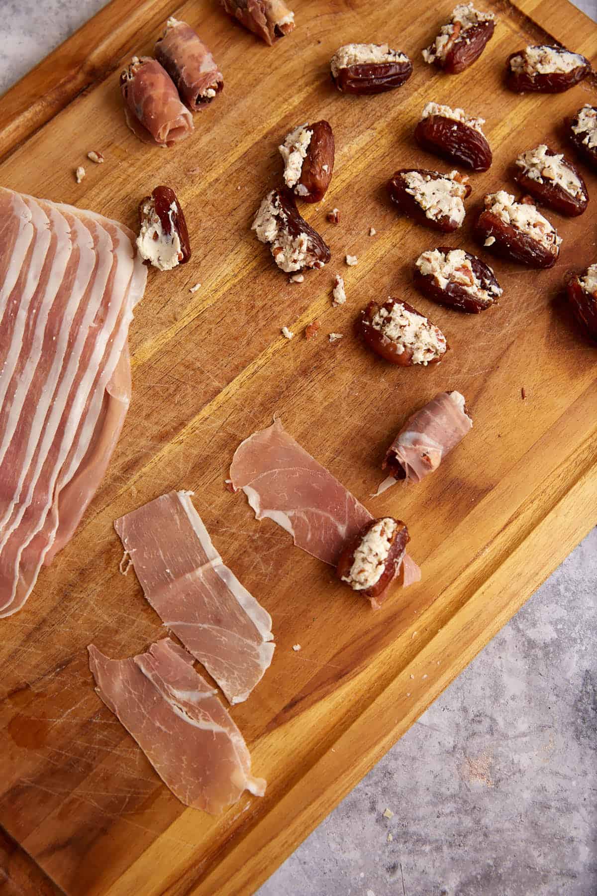 Strips of prosciutto next to stuffed dates.