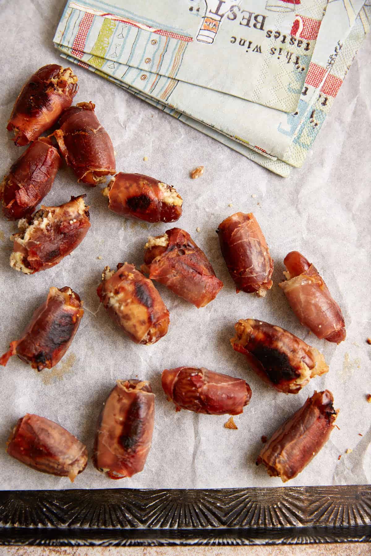 Dates on a platter next to cocktail napkins.