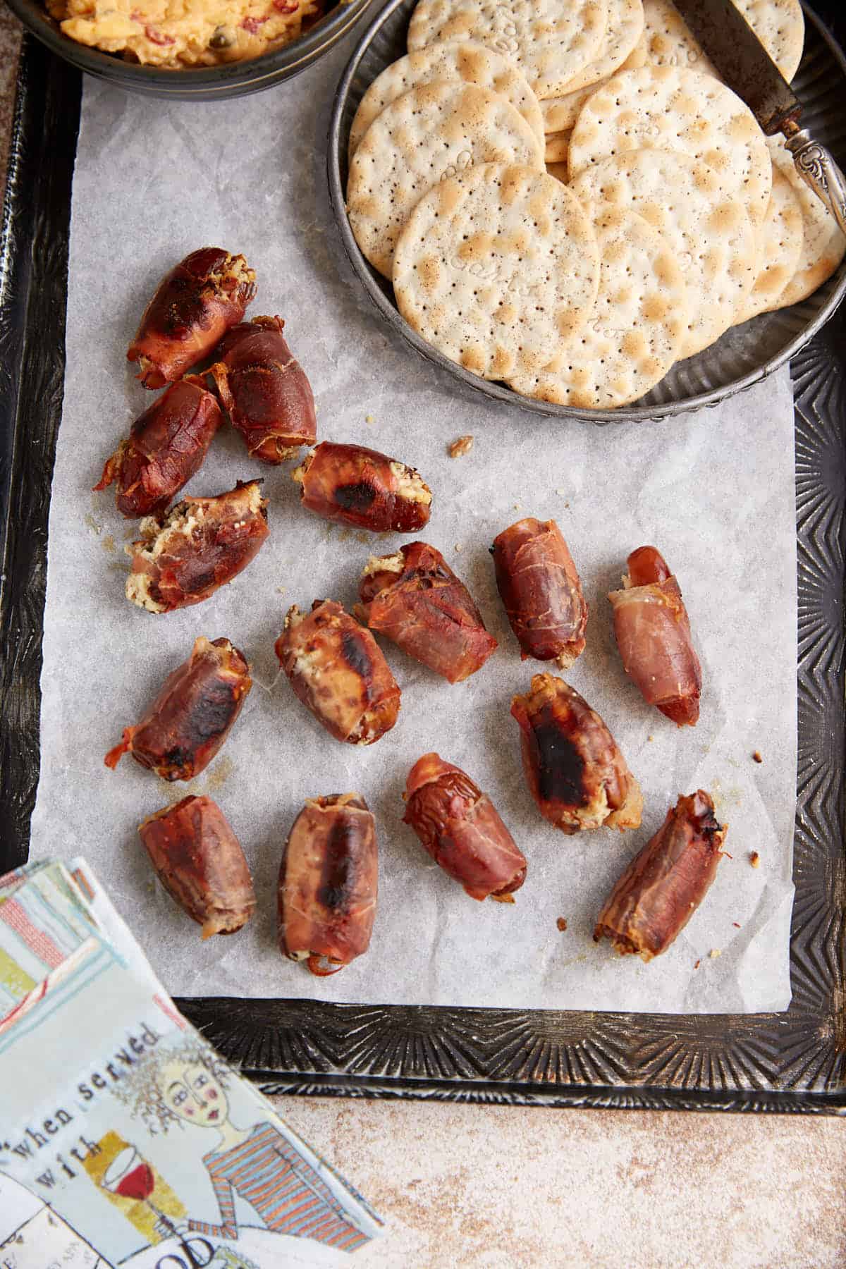 Dates on a platter next to pimento cheese and crackers.