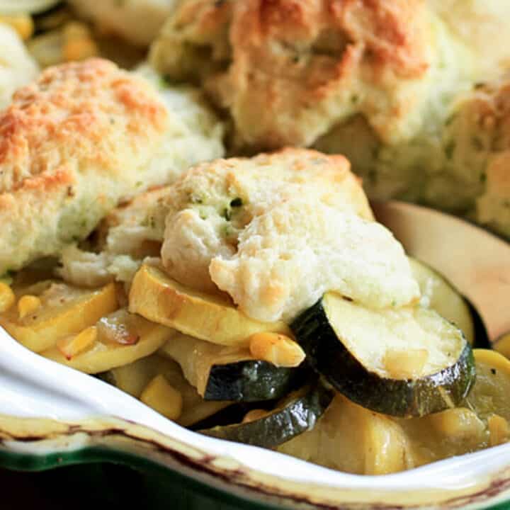 A serving of summer squash casserole with biscuits.