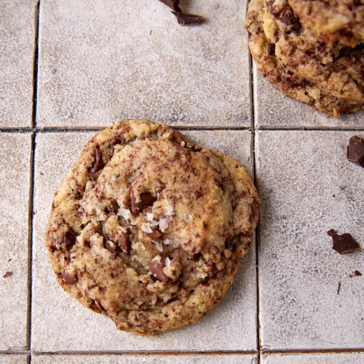 A single chocolate chip cookie with grated chocolate.