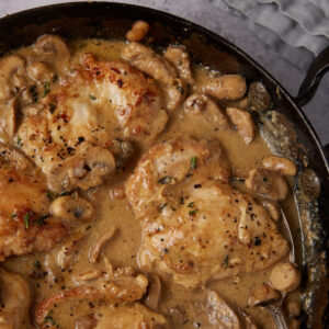 chicken and mushrooms in a skillet.