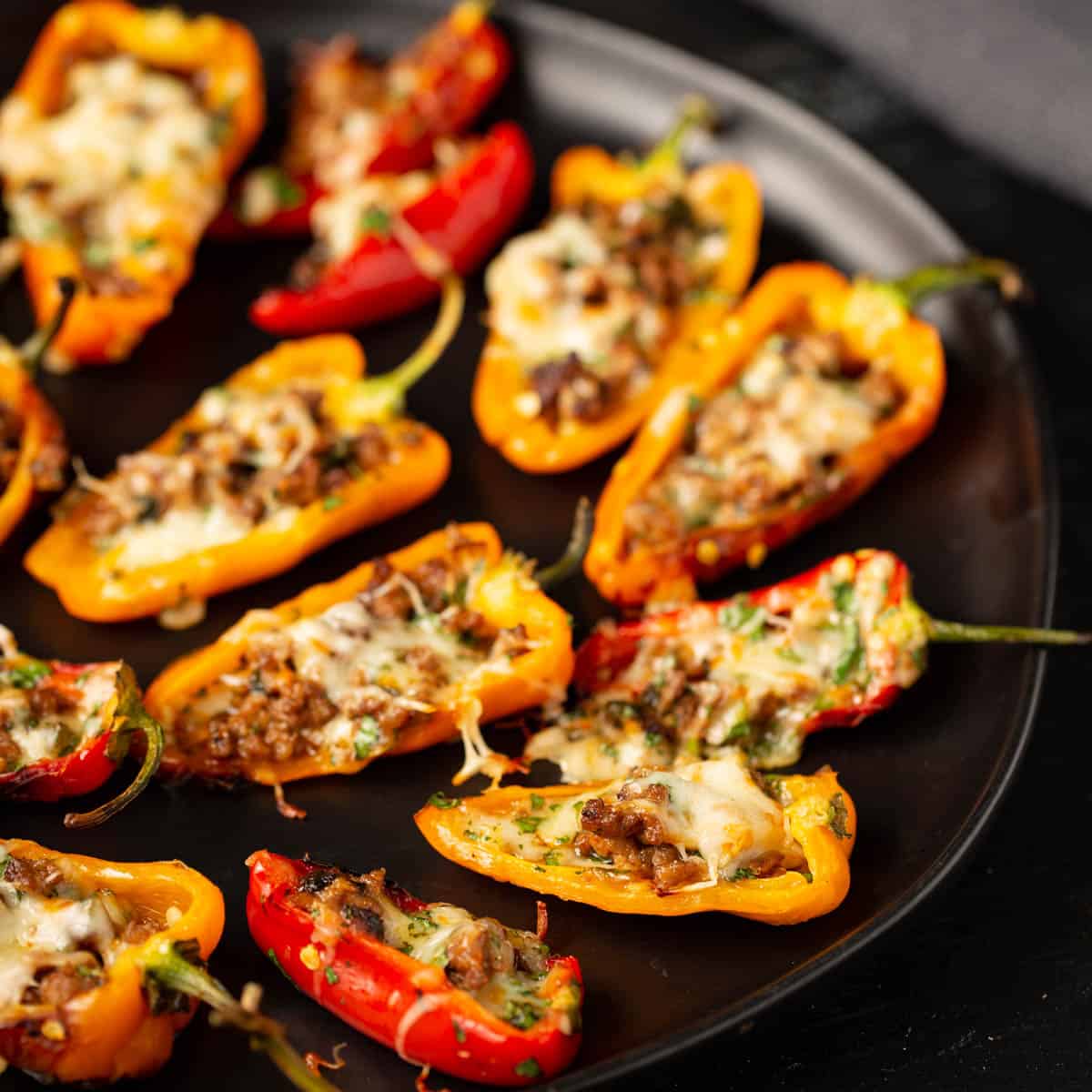 Peppers stuffed with cheese and sausage on a platter.