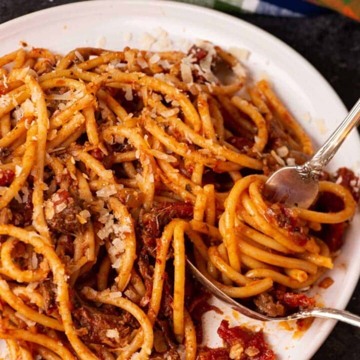 Pasta with Sunday gravy being twirled with two forks