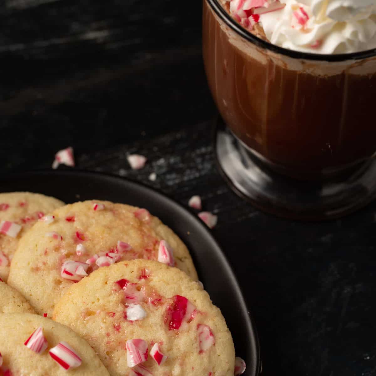Peppermint candy cane cookies next to a mug of hot chocolate.