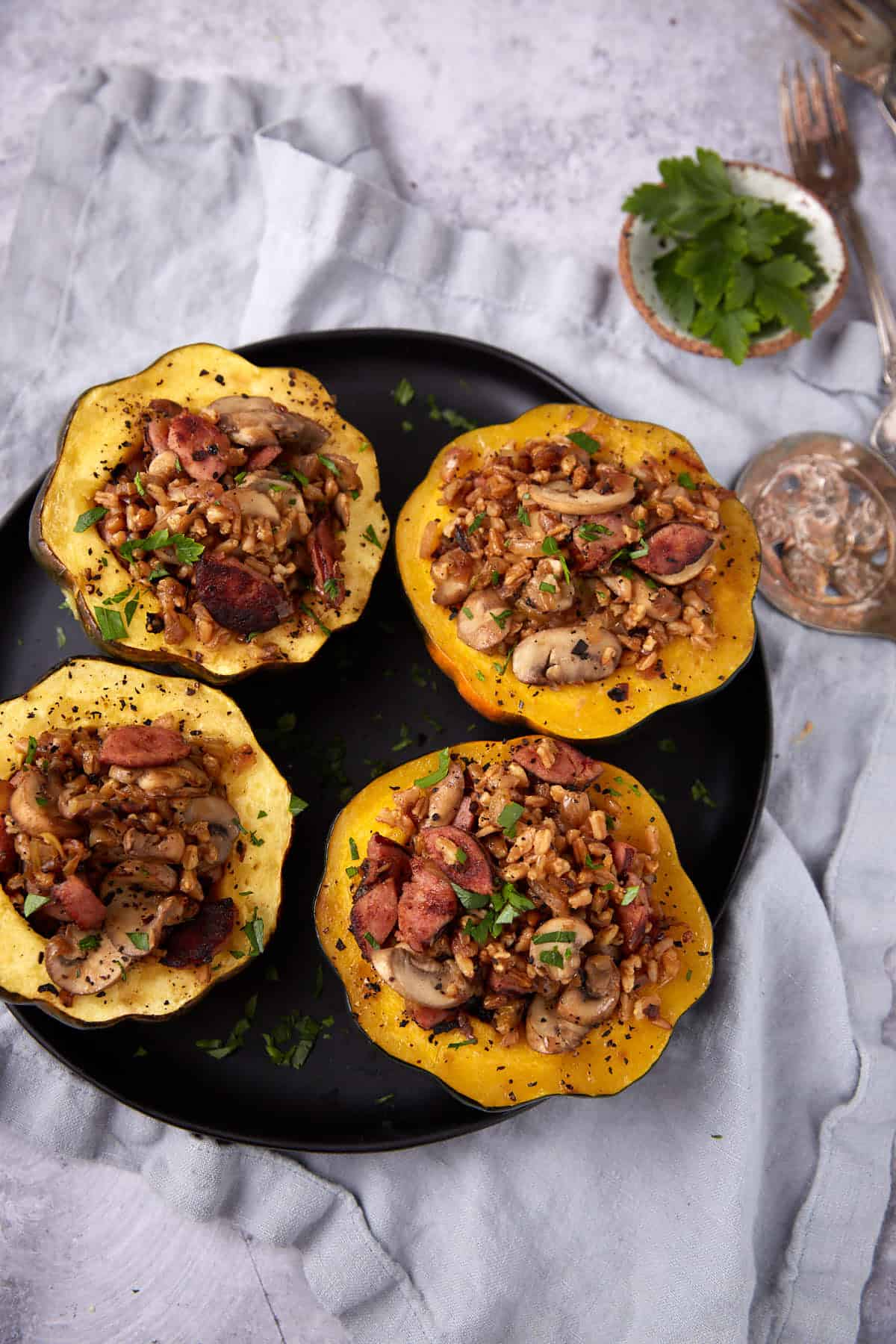 stuffed acorn squash halves on a black plate.