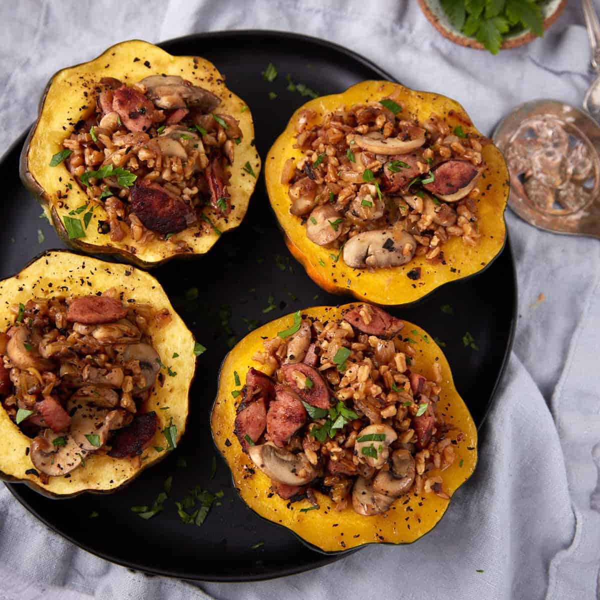 stuffed acorn squash halves on a black plate.