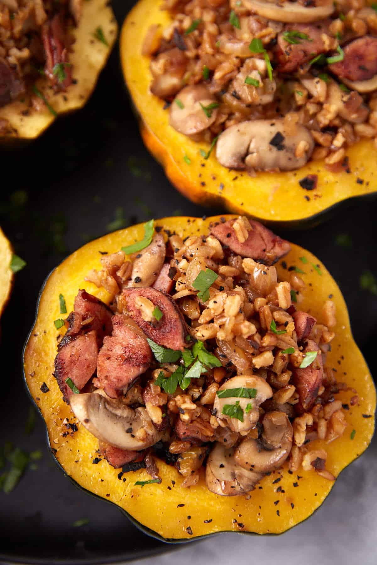 stuffed acorn squash halves on a dark background. 