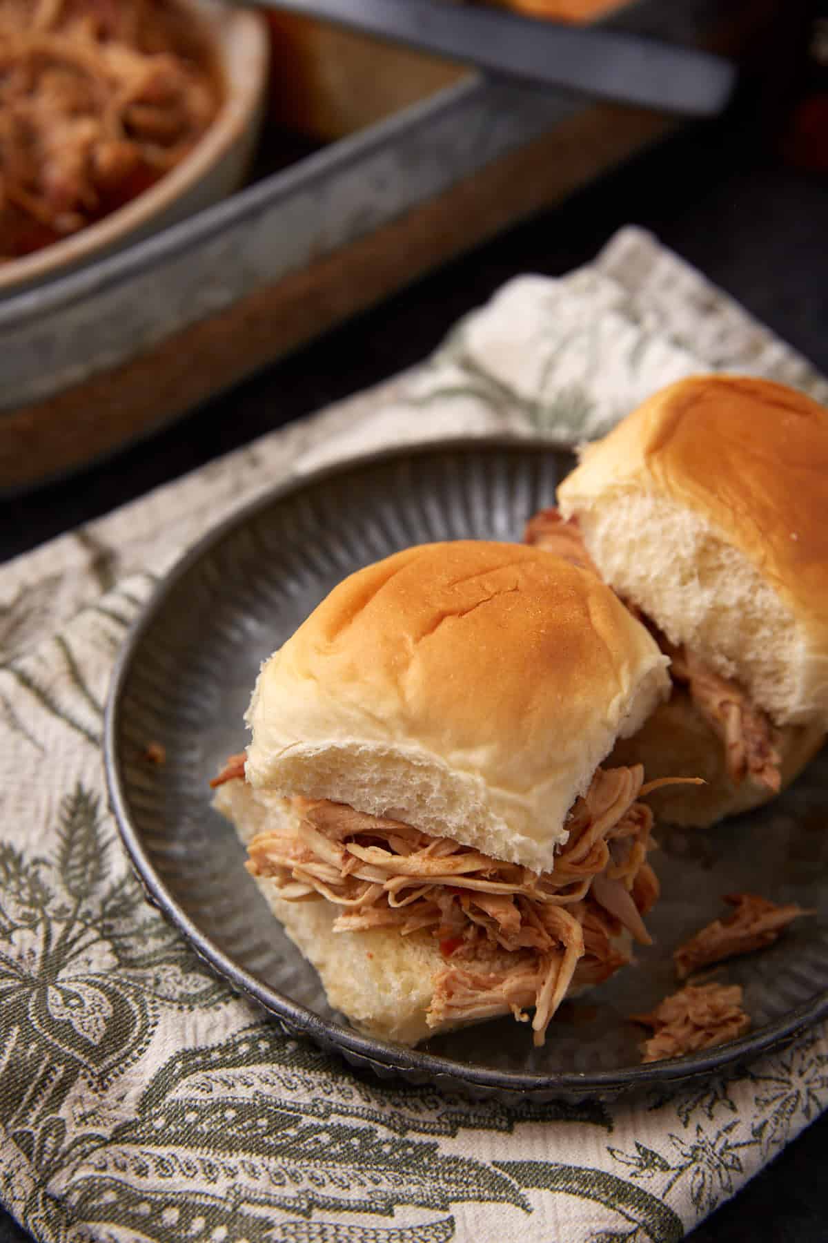 two pulled chicken sliders on a plate.