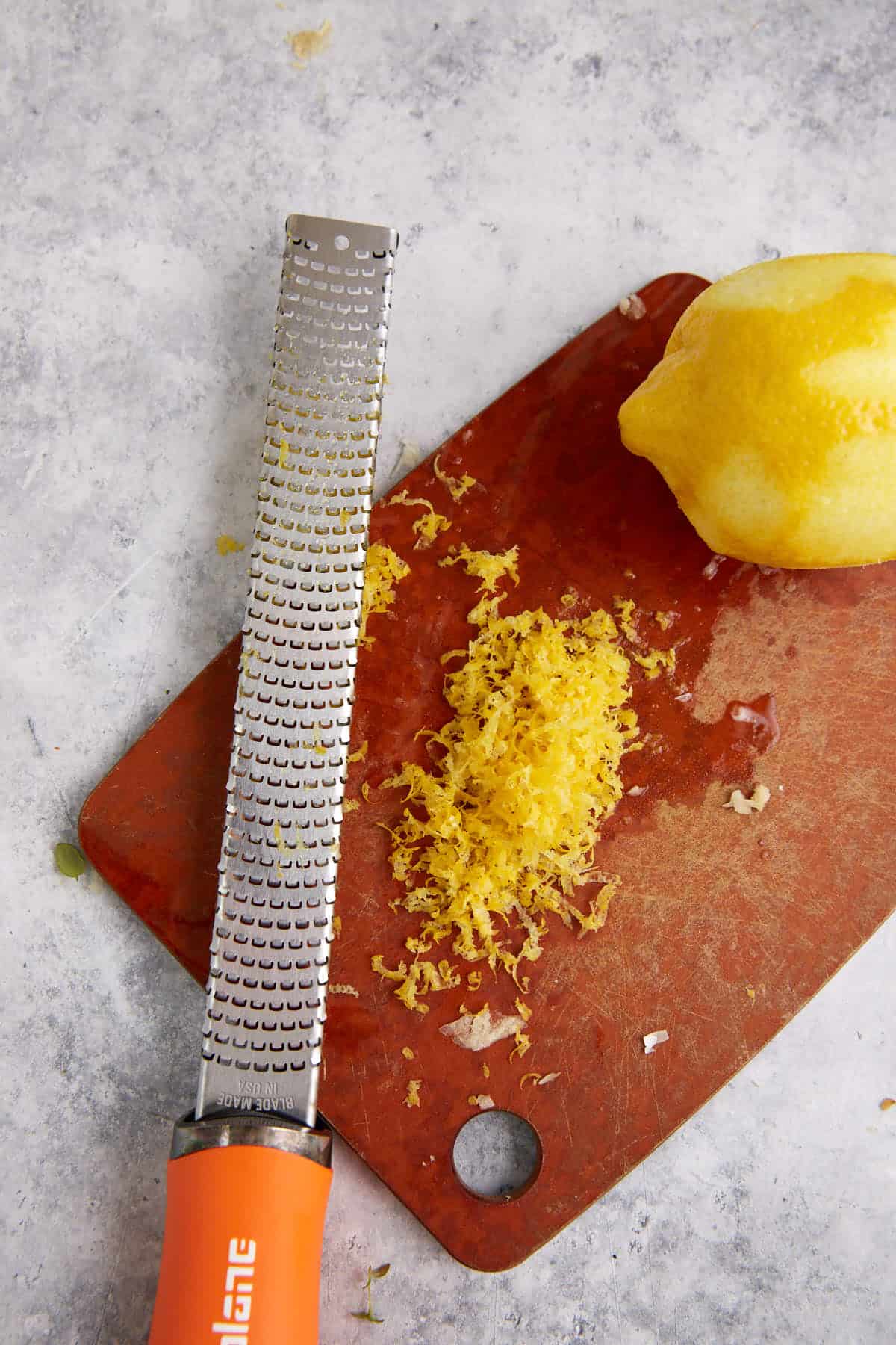 A lemon zested on a cutting board.