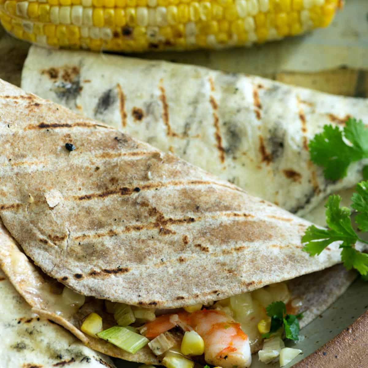 A grilled tortilla stuffed with shrimp and corn