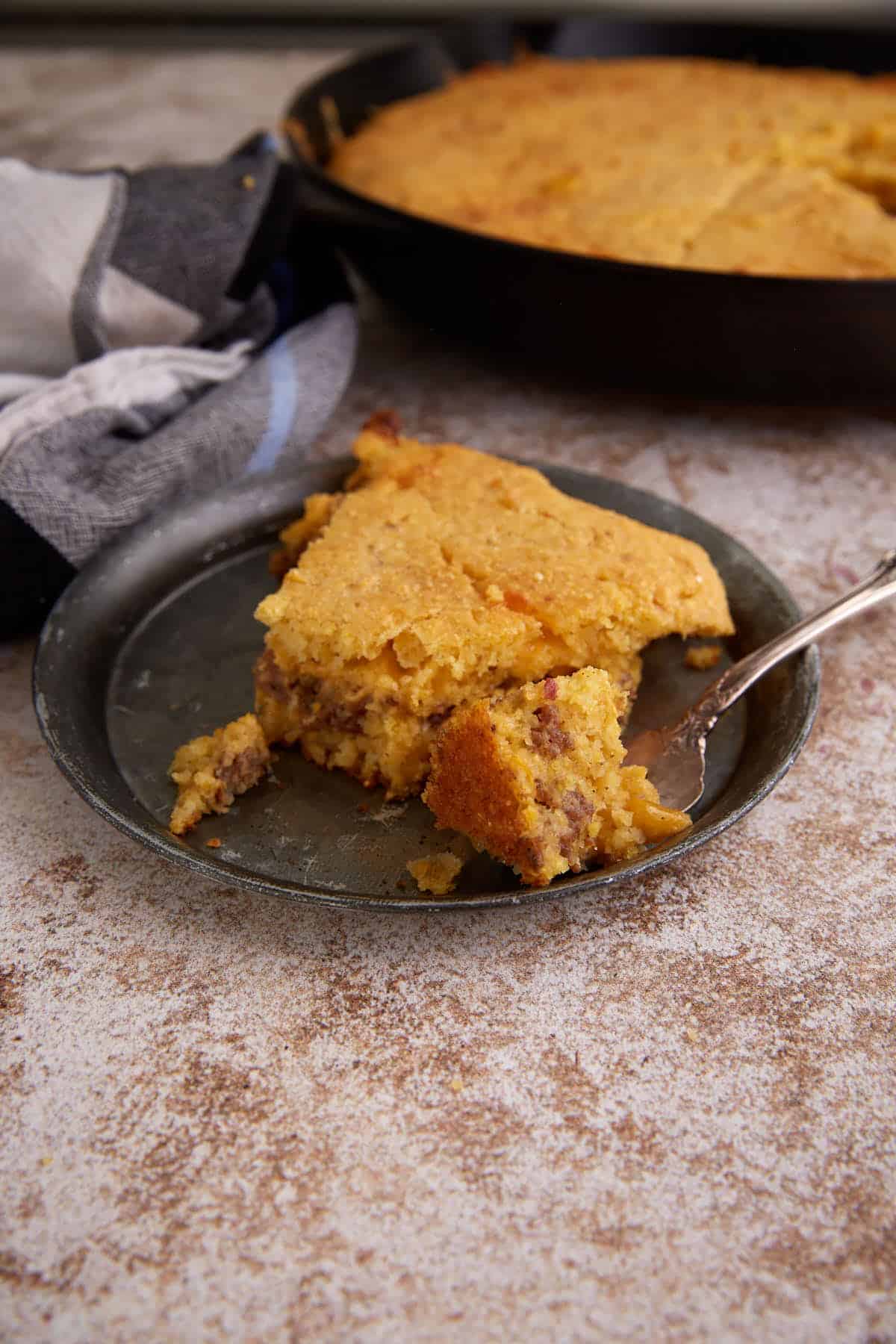 A slice of sausage cornbread on a plate.