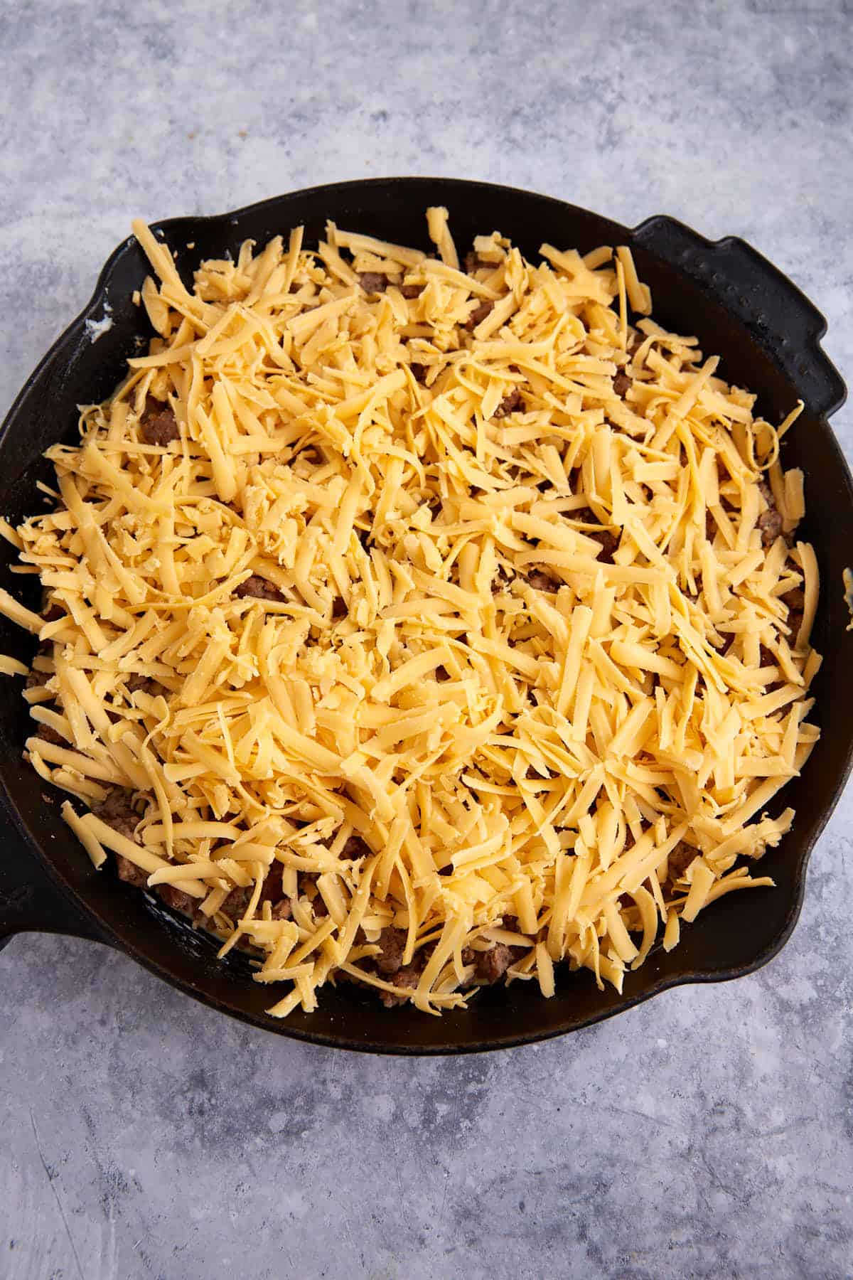 A layer of cheese on top of sausage.