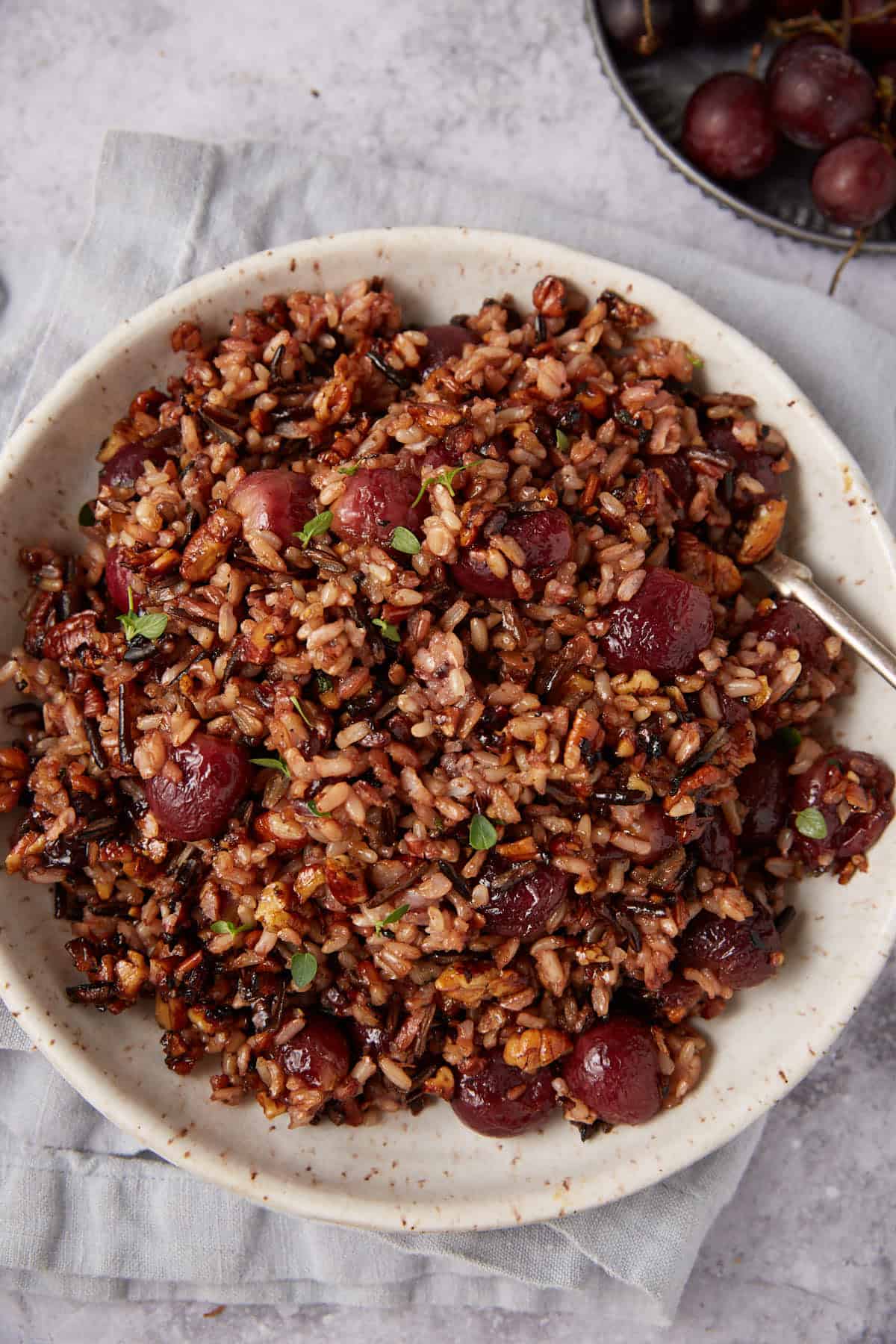 wild rice with roasted grapes in a white bowl.