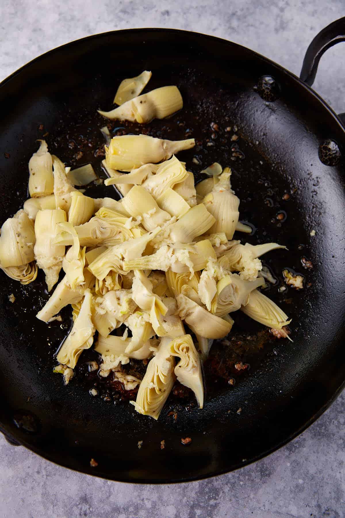 A skillet of artichoke hearts.