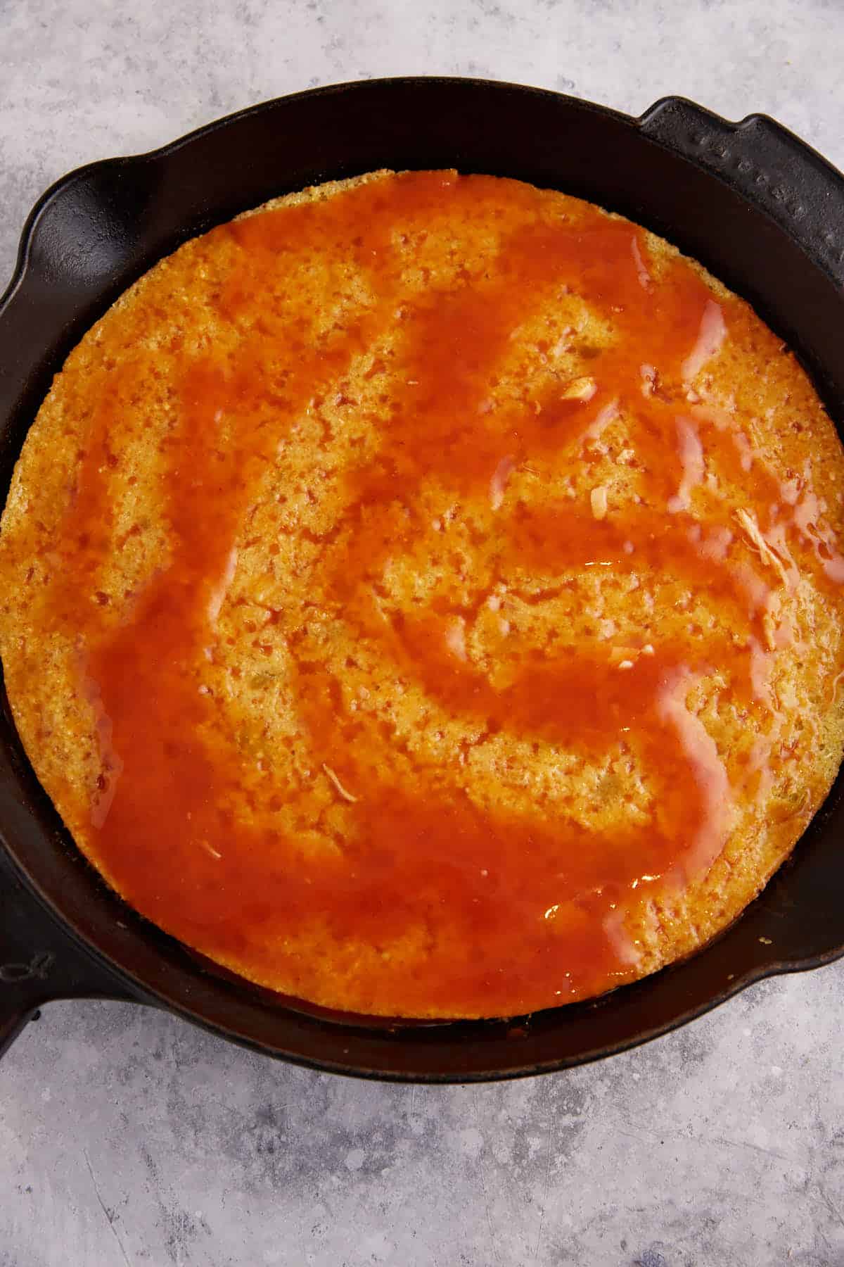 Enchilada sauce spread over cornbread.