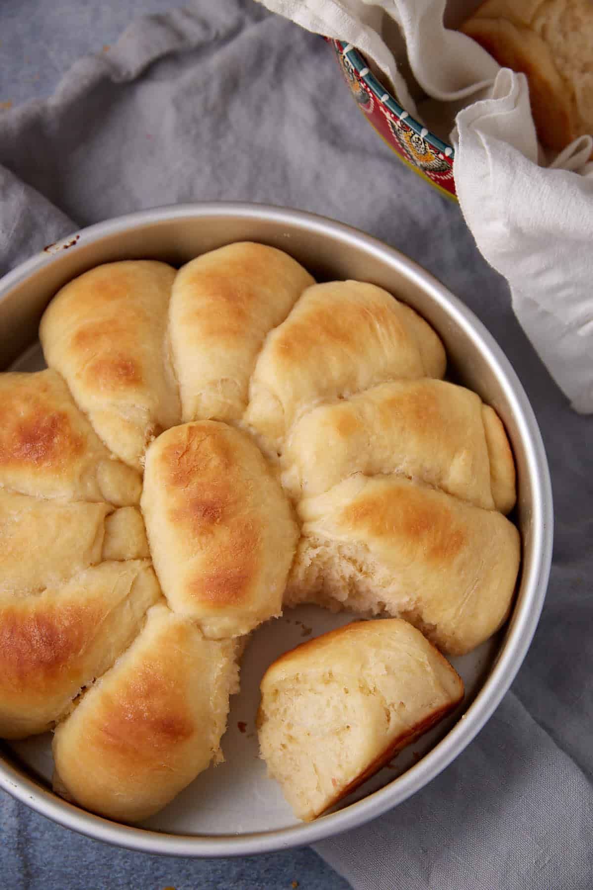 A cake pan with baked yeast rolls.