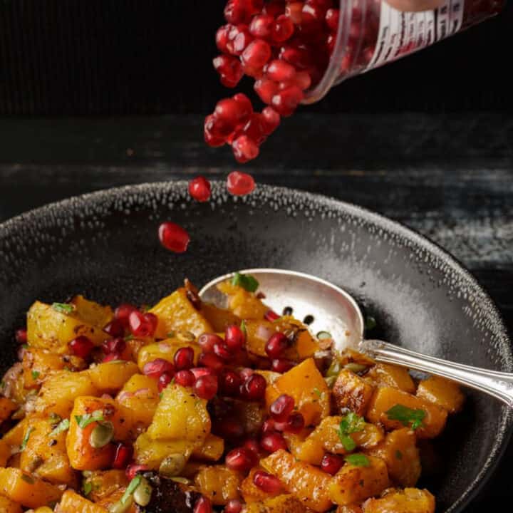 Pomegranate seeds sprinkled over butternut squash salad.