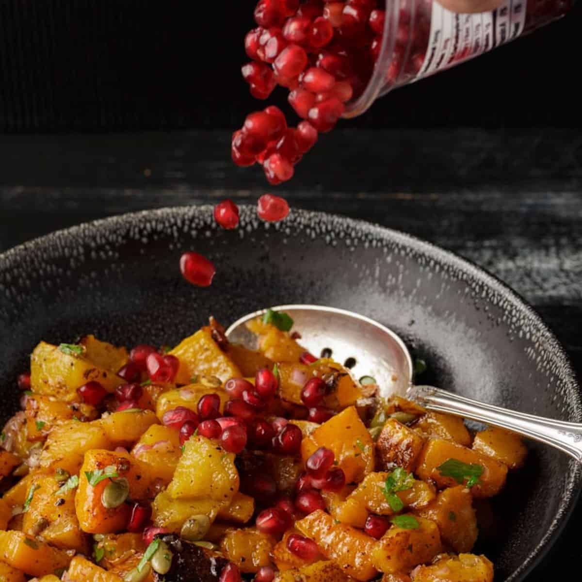 Pomegranate seeds sprinkled over butternut squash salad.