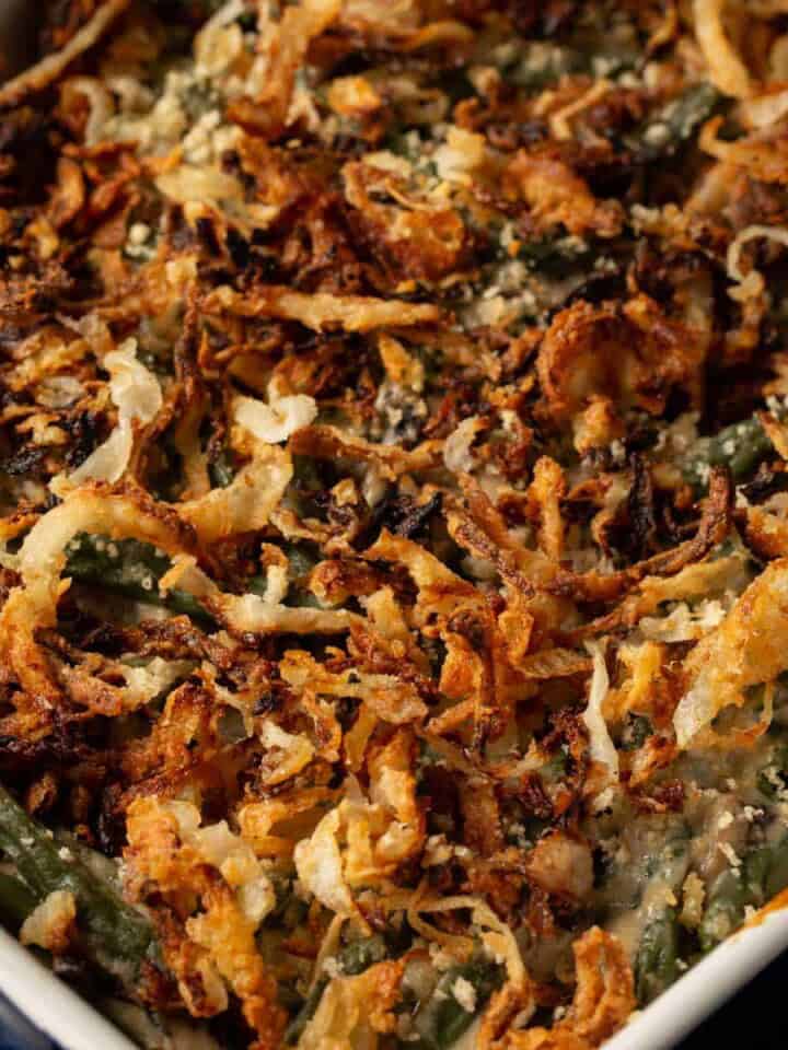 A casserole dish of green bean casserole topped with crispy onions.