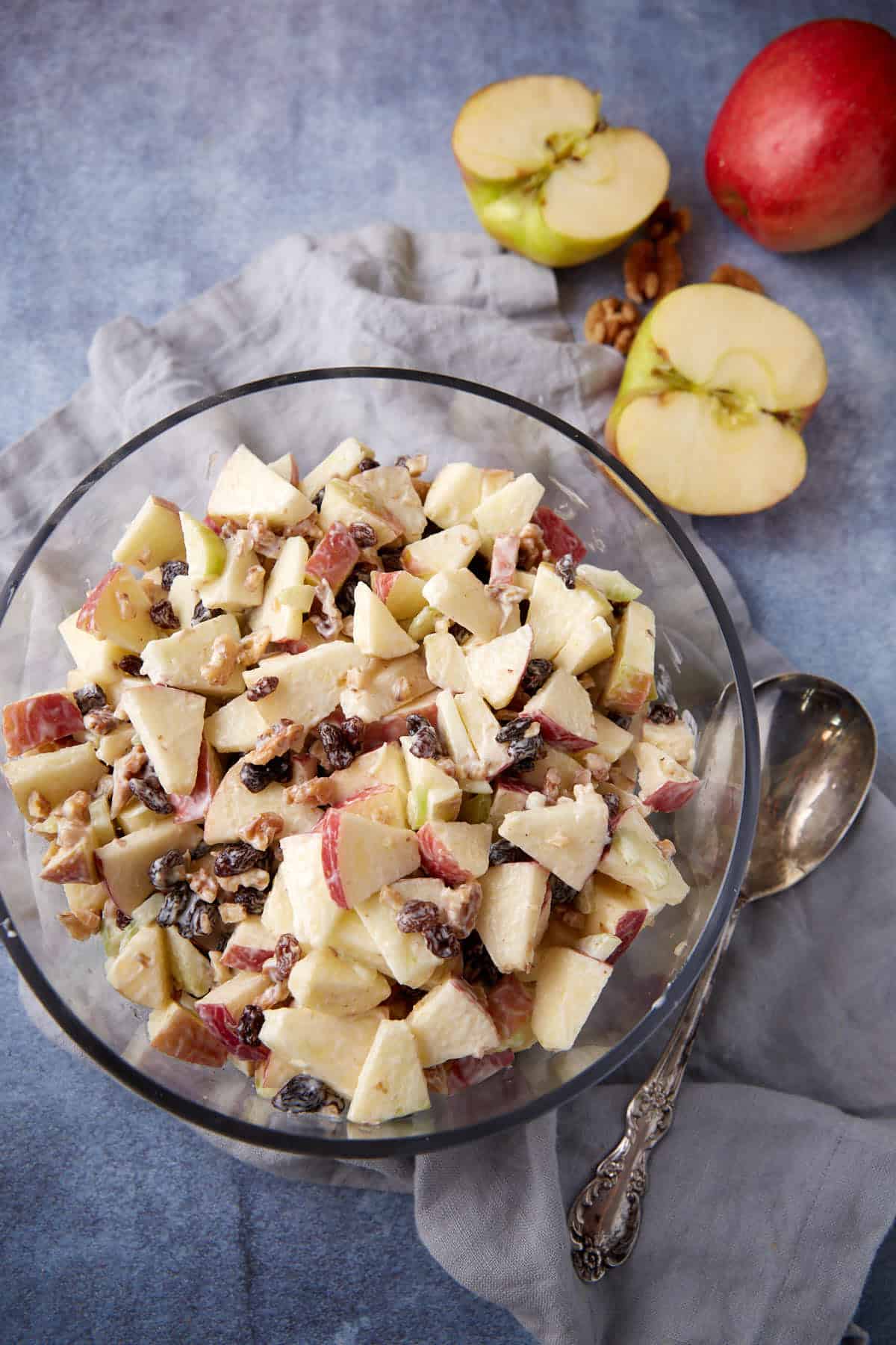 A bowl of apple salad with a serving spoon next to it. 