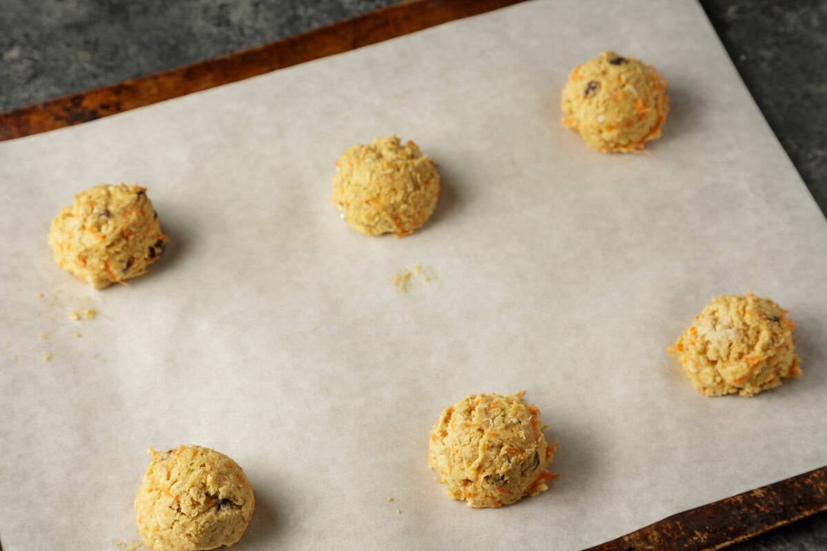 Balls of cookie dough on parchment paper.