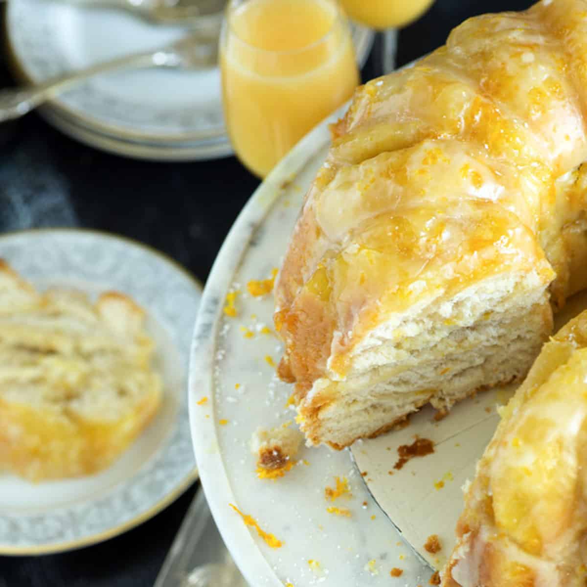 A bundt cake with a mimosa glaze on a marble platter.