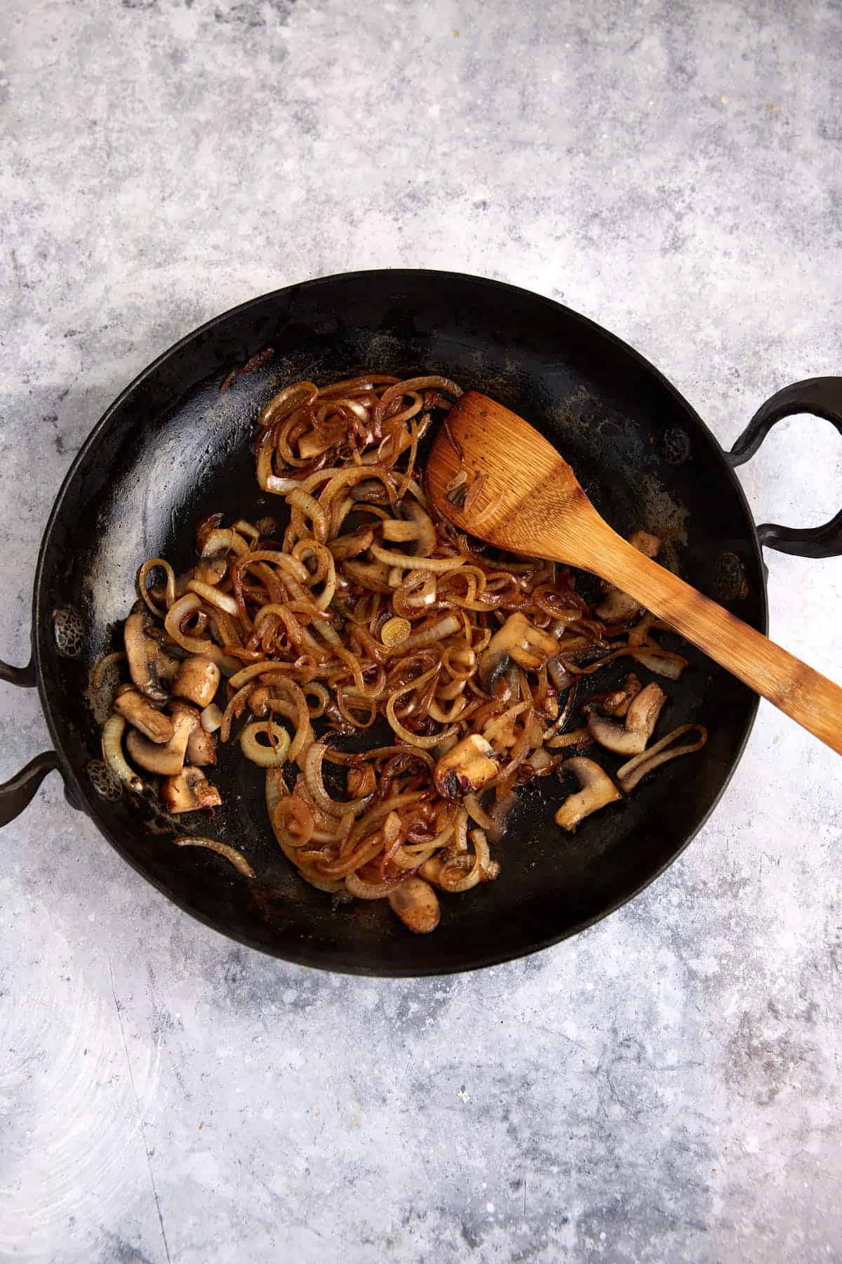 A skillet of cooked onions and mushrooms.