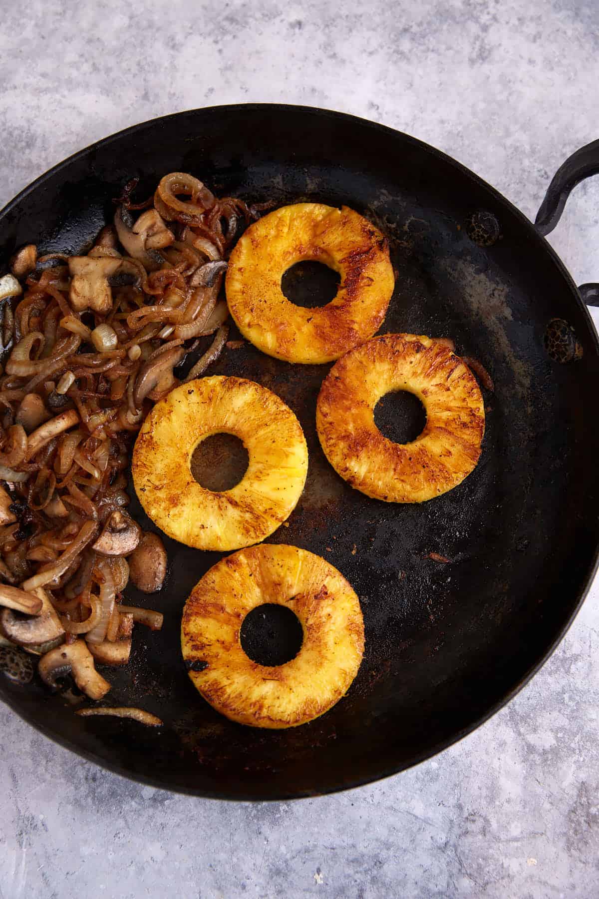 Pineapple slices in a skillet.