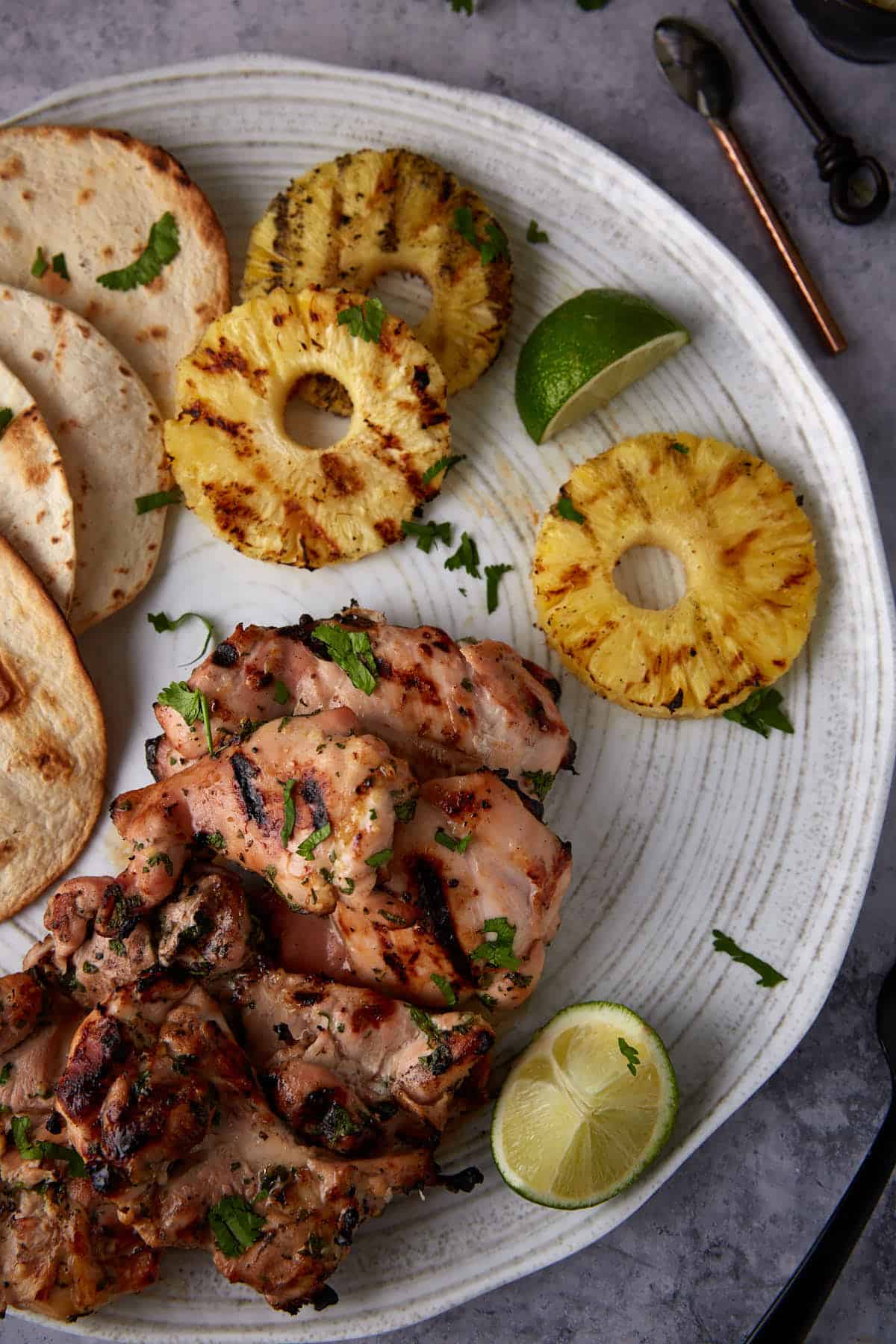 A platter of grilled chicken with grilled pineapple.
