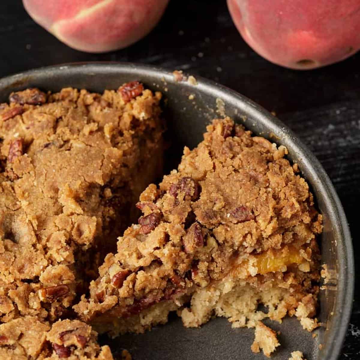 Slices of peach coffee cake in a cake pan.