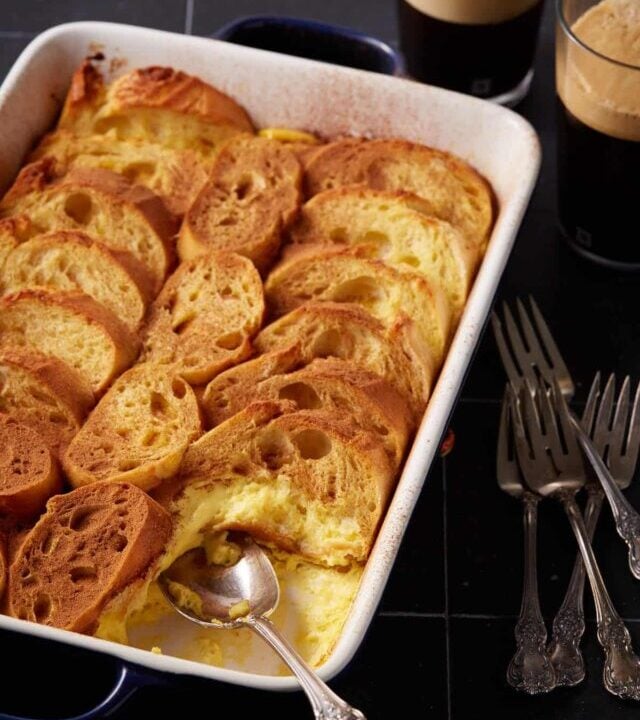 An eggnog overnight casserole next to coffee cups.