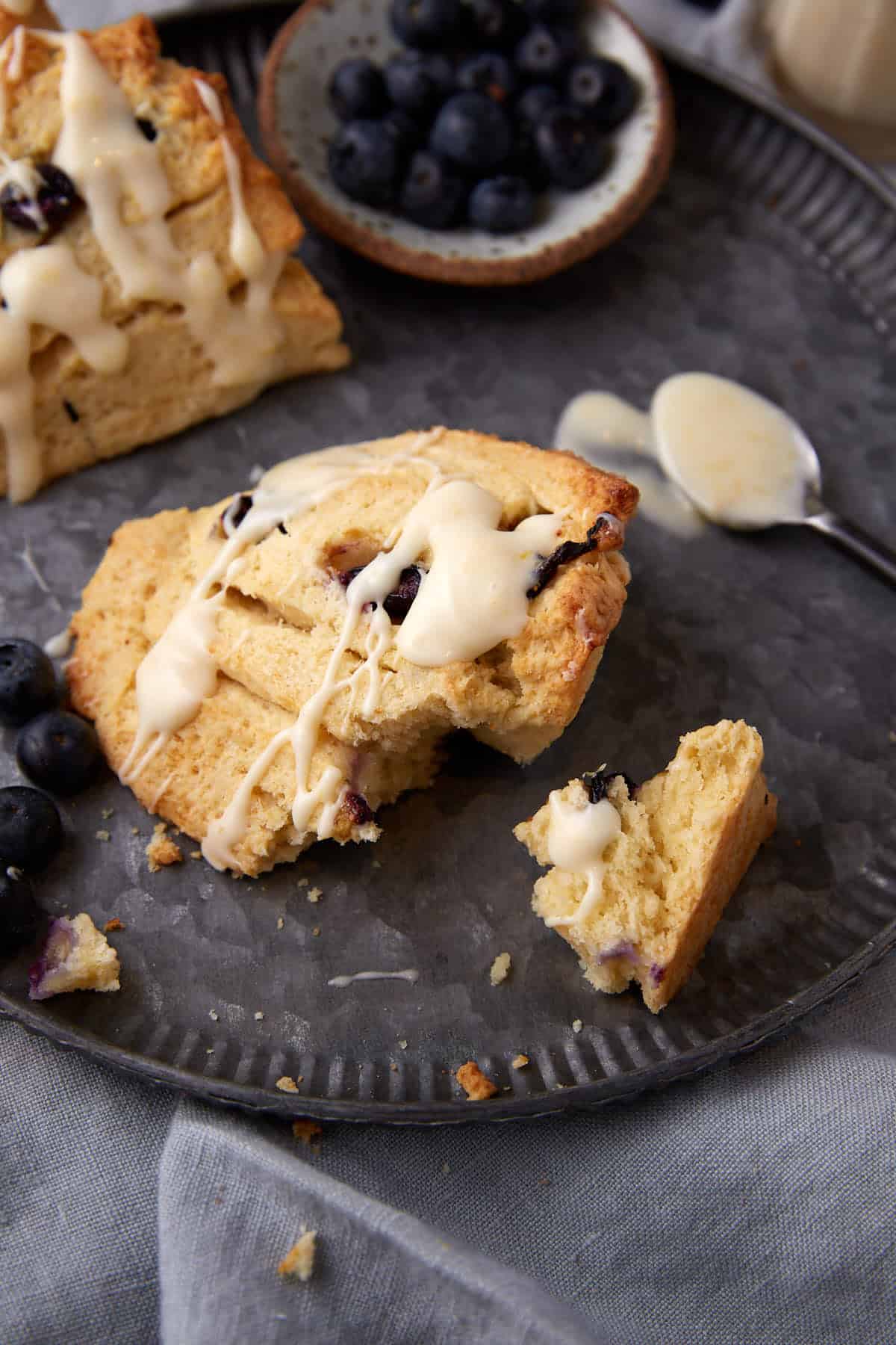 A blueberry scone broken apart on a plate.