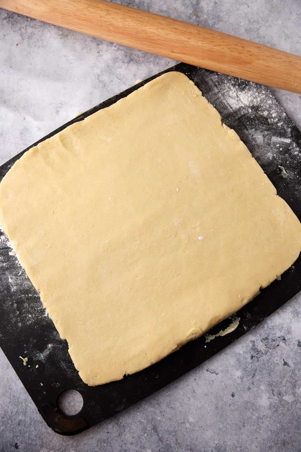 A square of scone dough on a cutting board.