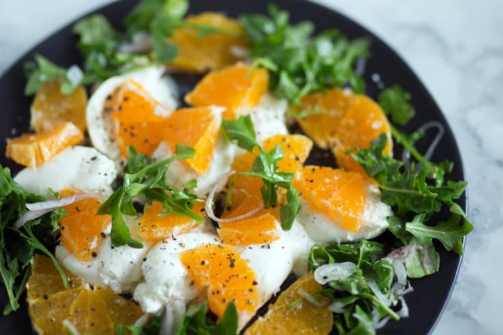 A plate of burrata and orange slices