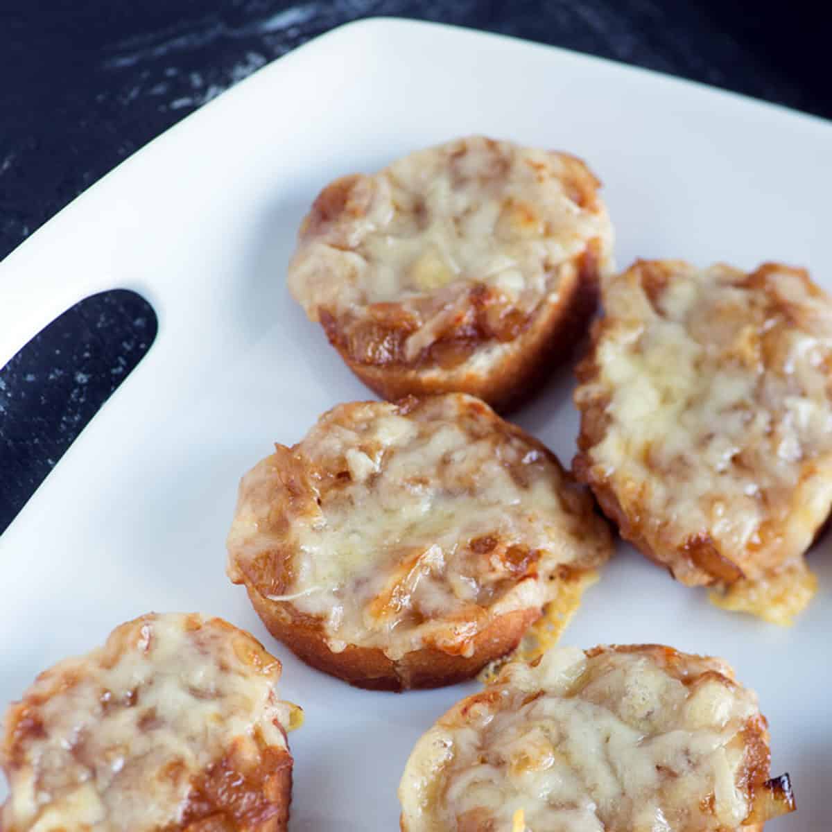 French onion crostinis on a platter.