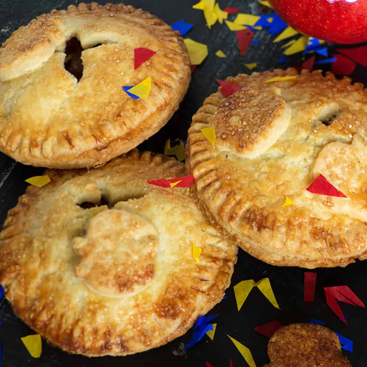 Mini apple hand pies next to some apples.