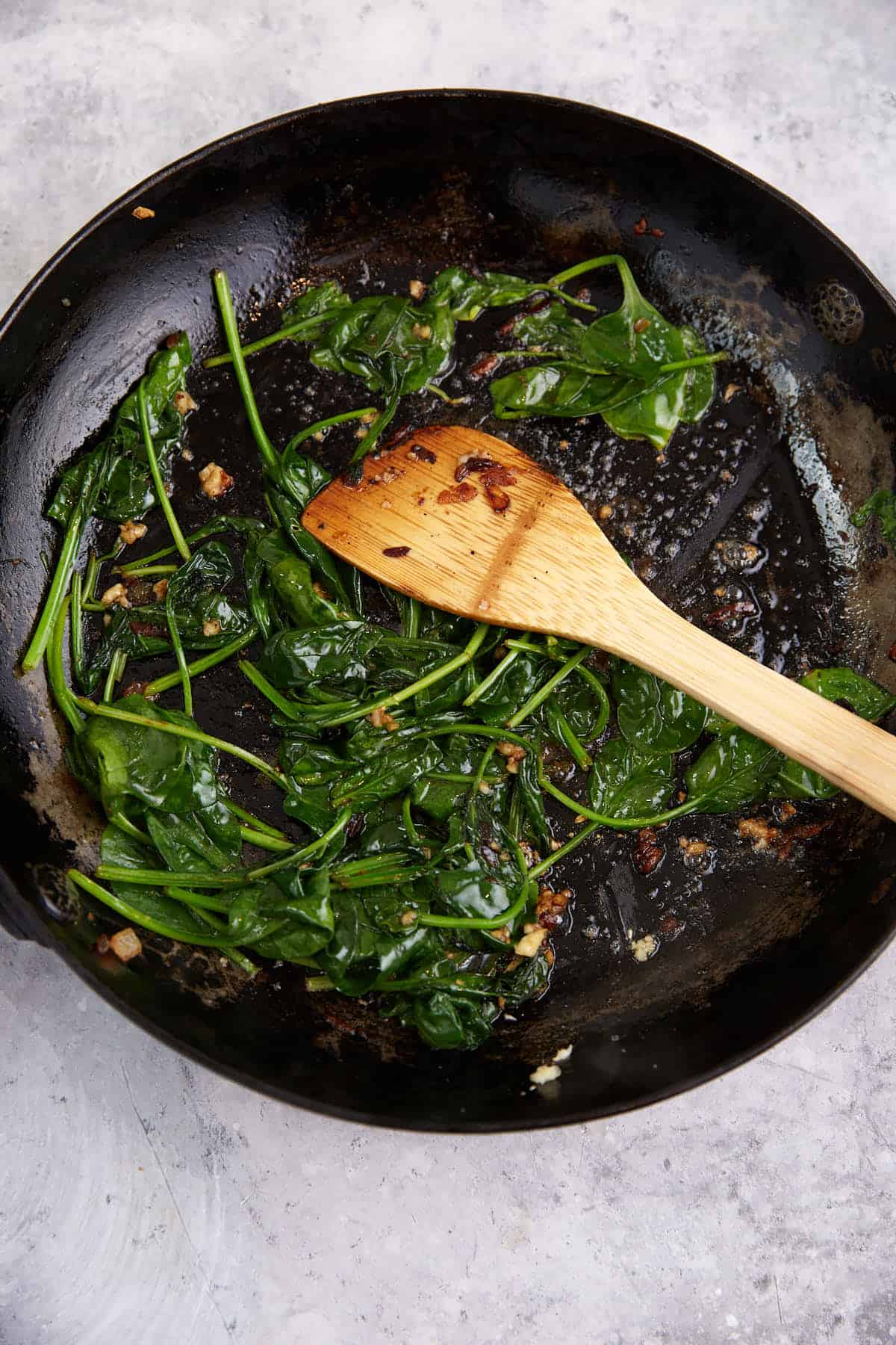 Spinach that has cooked in a skillet.