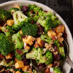 A serving spoon in a bowl of broccoli salad.