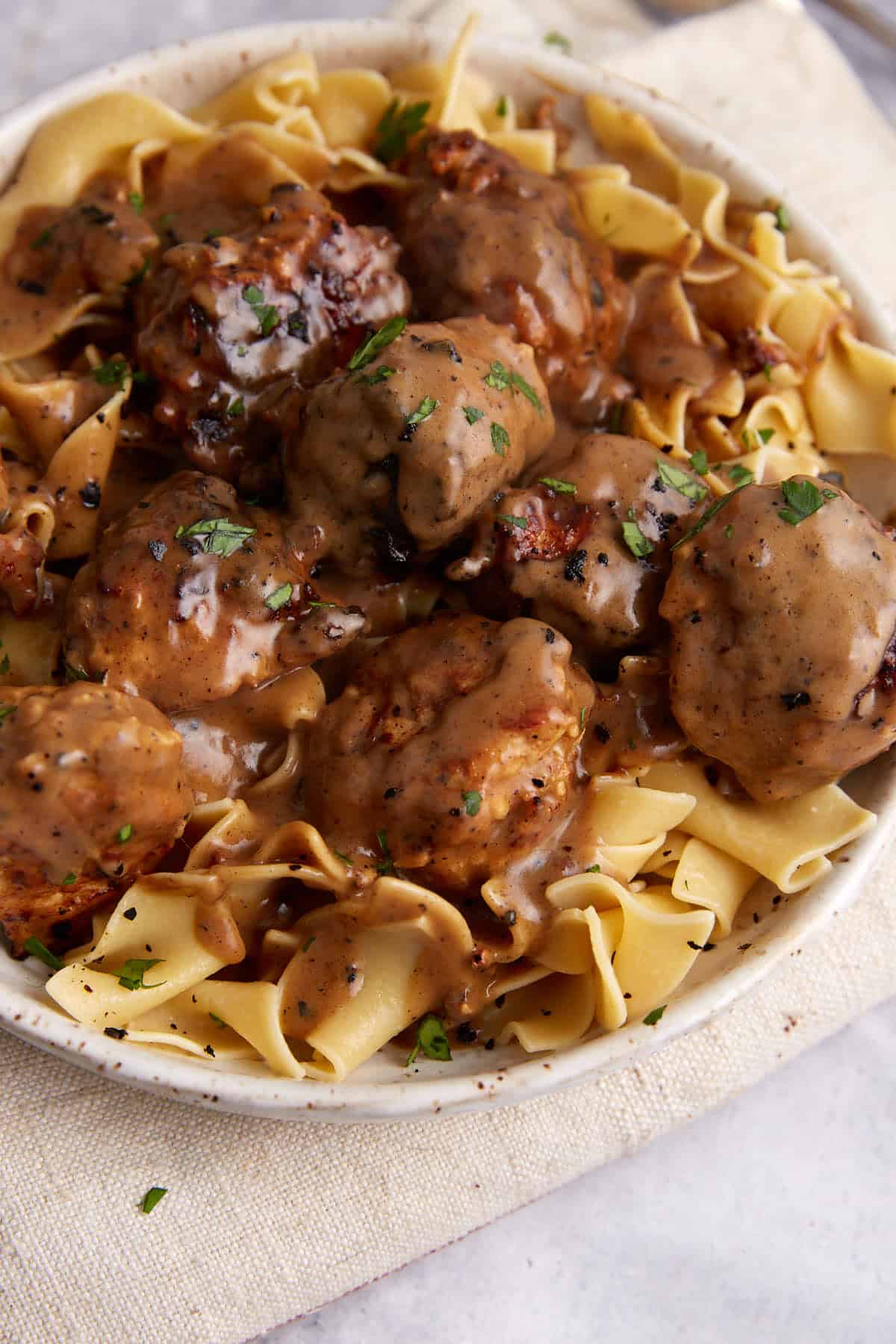 A platter of chicken meatballs covered in Marsala sauce.