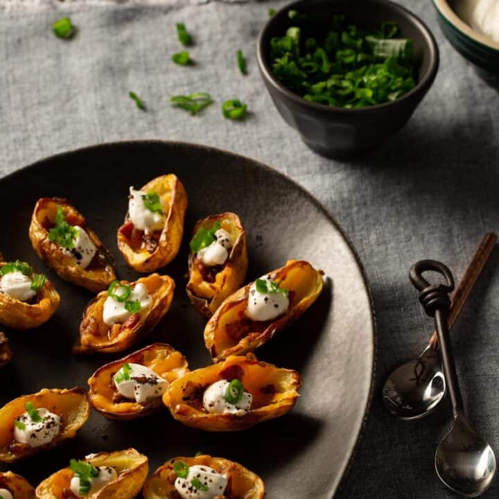 A black platter filled with mini potato skins.