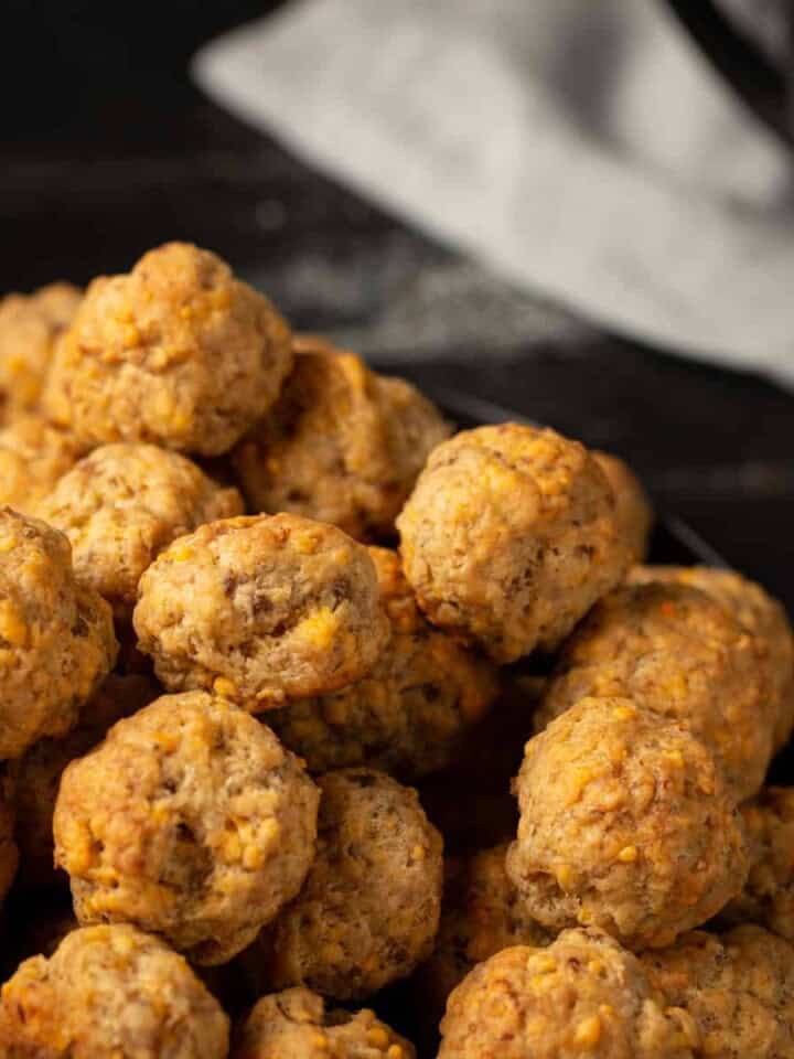 A pile of sausage balls with a linen napkin in the background.